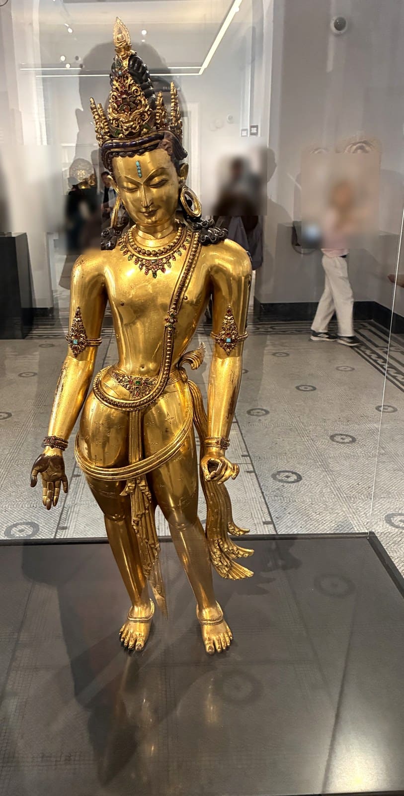 Gilded copper standing figure of the Bodhisattva Avalokiteshvara with a jewelled crown, in a glass case