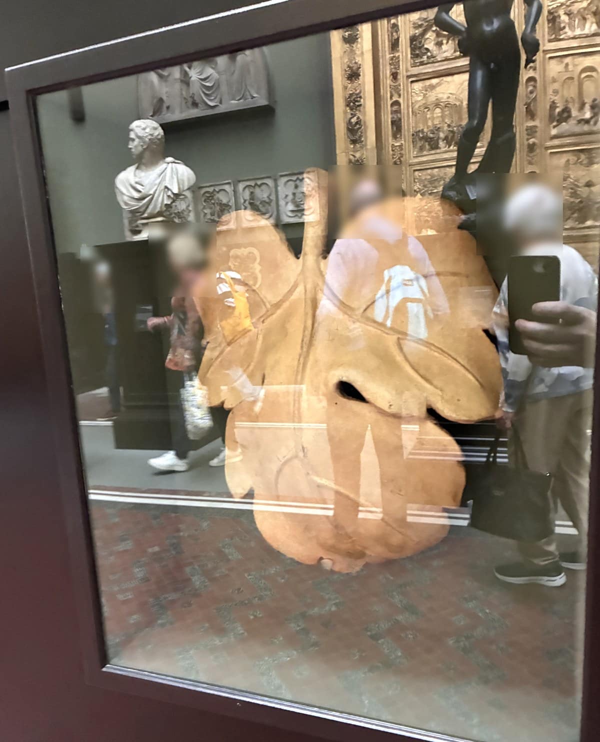 The plaster fig leaf made for the cast of Michelangelo's David, displayed in a glass case with the gallery reflected in it