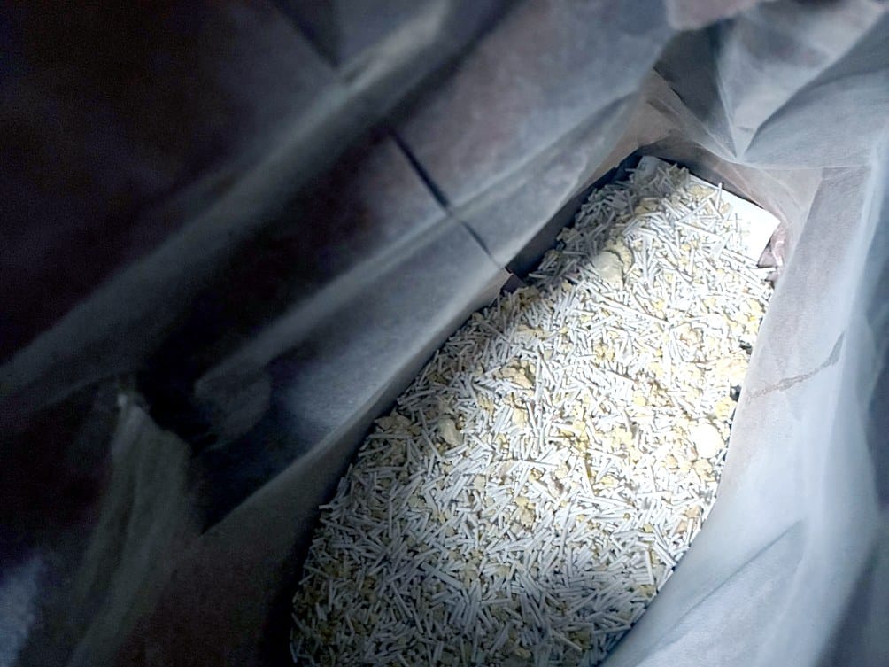 Close-up of KatKin Scoop Planet plant-based cat litter pellets inside the paper bag